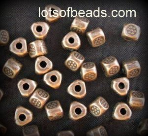 Copper triagle bead with stamped flower